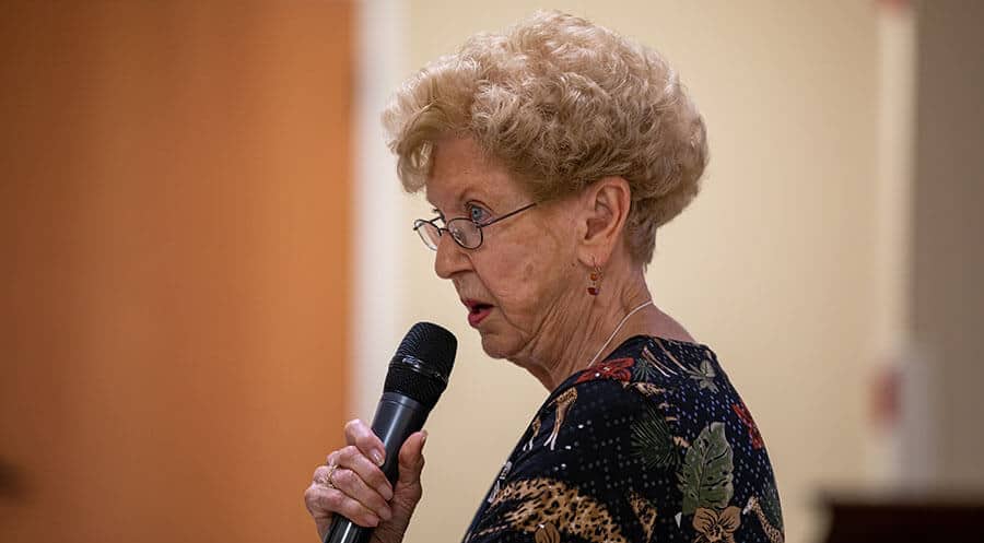 older woman speaking into microphone