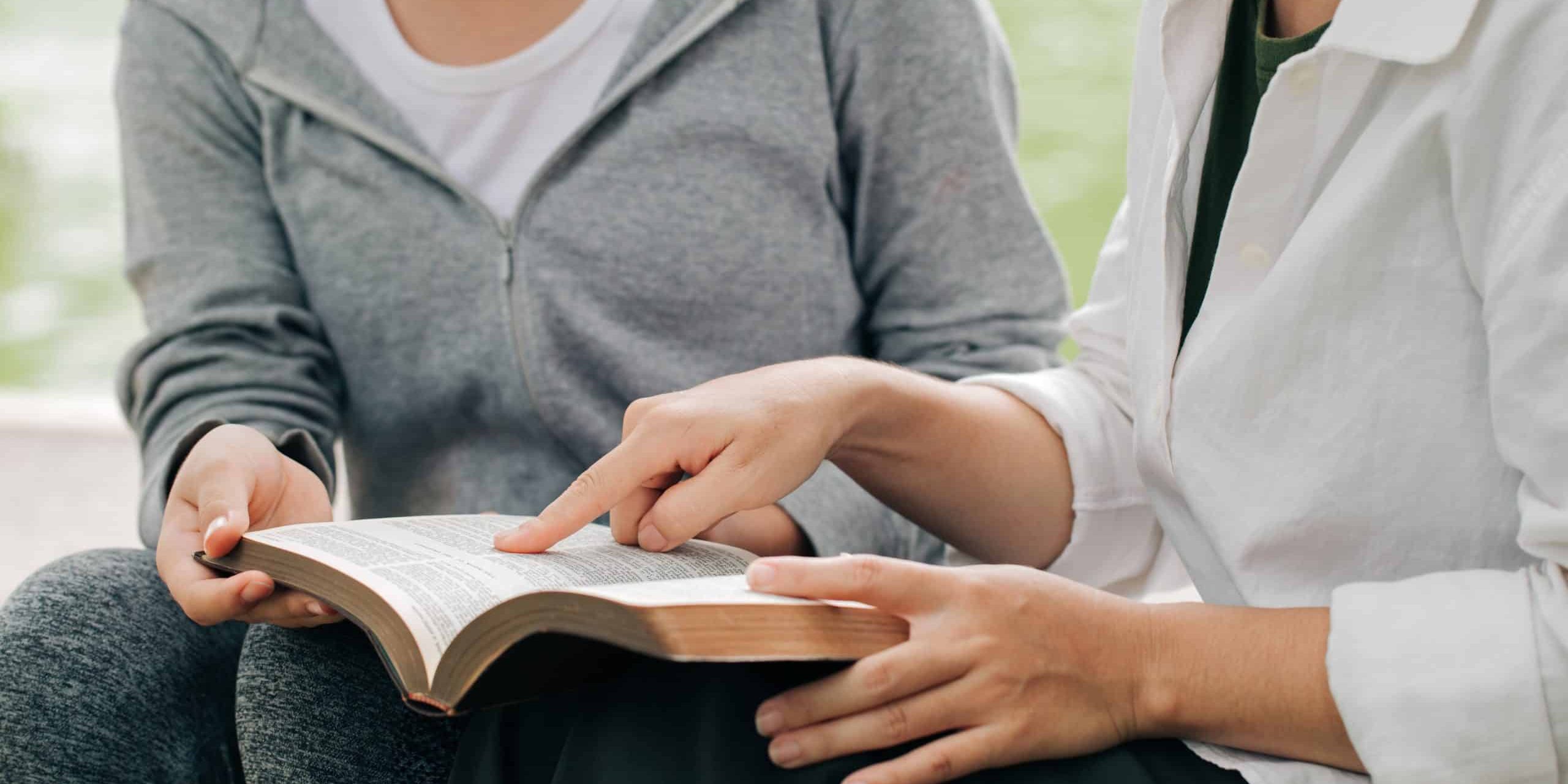 Two women studying and talking about the bible . Two women studying and talking about the bible .
